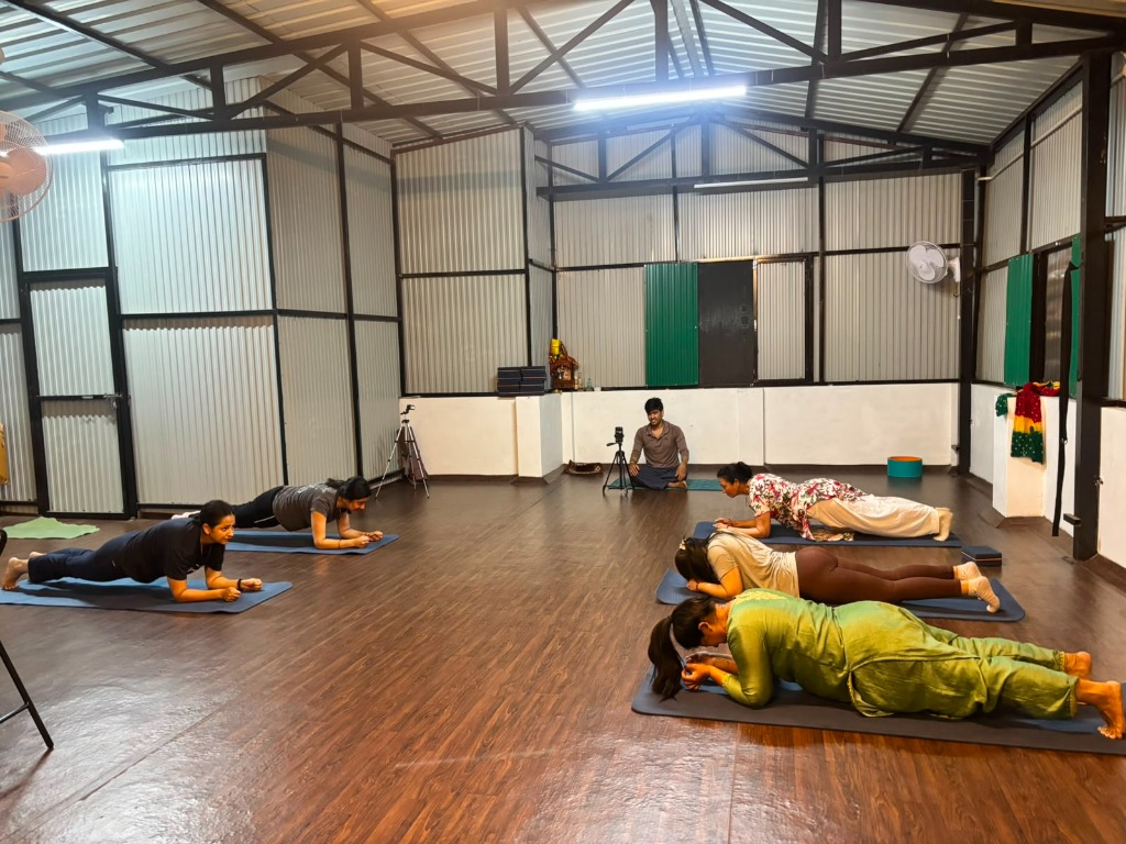 Group yoga class practicing planks in the studio