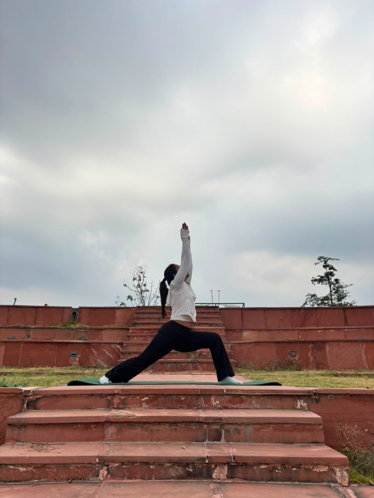 Warrior pose crescent lunge on red stone stairs